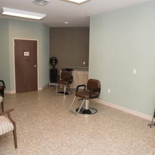 A modern hair salon's waiting area featuring stylish chairs and a minimalist decor.