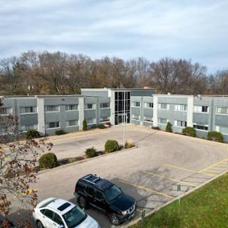Aerial view of a modern apartment complex with an adjacent parking lot.