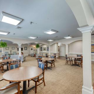 A spacious, well-lit dining area with multiple tables and chairs arranged in an orderly fashion.