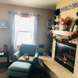 A cozy living room with a fireplace and a comfortable chair by the window.