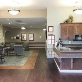 A cozy interior featuring a kitchen and dining area with wood flooring and soft lighting.