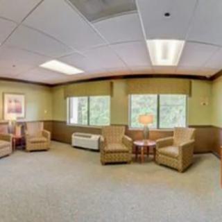 A well-lit waiting room with comfortable chairs and large windows.
