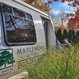 A Maplewood van is parked outdoors, surrounded by autumn foliage.
