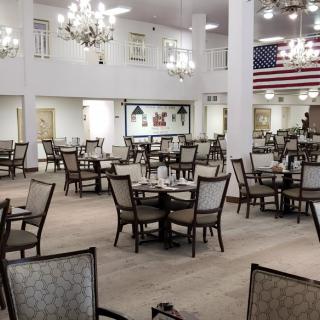 A spacious dining area with chandeliers and an American flag displayed on the wall.