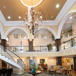 A luxurious hotel lobby featuring a grand chandelier and elegant staircase.