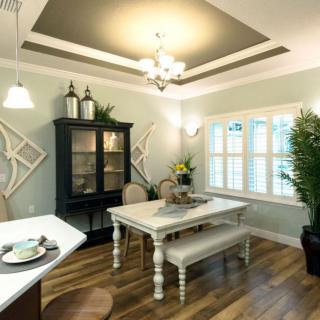 A well-furnished dining room with a chandelier, elegant table and chairs, and decorative plants.