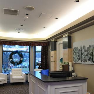 A modern reception area with comfortable seating and a decorative wreath on the window.