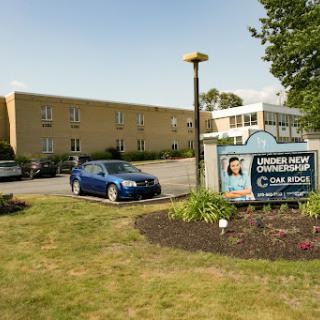 Exterior view of a commercial building with signage and vehicles in the parking area.