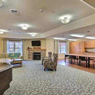 A spacious and well-lit living area featuring comfortable seating, a fireplace, and a piano.