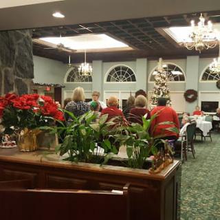 A festive gathering in a decorated room with a Christmas tree and holiday decorations.