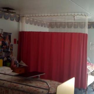 A hospital room with a privacy curtain around the bed.