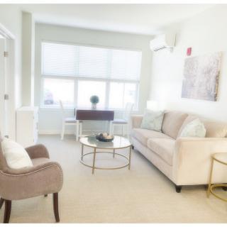 A bright and modern living room with a sofa, armchair, and coffee table.