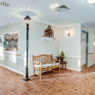 A cozy hallway with a wooden bench, decorative artwork, and a unique indoor lamp post.