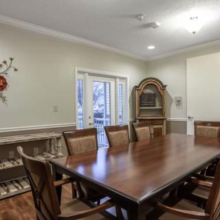 A cozy dining room with a wooden table, surrounded by chairs, featuring elegant interior decor.