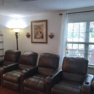 A cozy home theater setup with leather recliners and warm lighting.