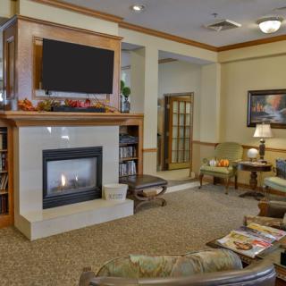 A cozy living room interior featuring a fireplace, television, and comfortable seating.