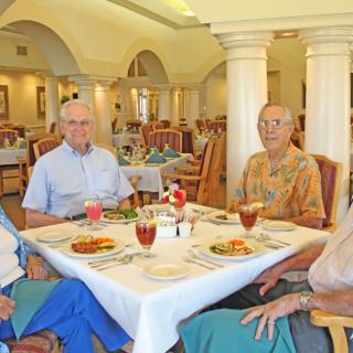 A group of elderly people enjoying a meal together in a restaurant setting.