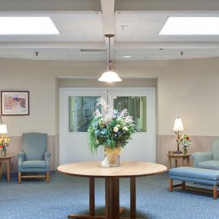 A welcoming lobby area with comfortable seating and a decorative flower arrangement on a central table.