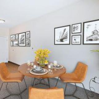 A modern dining room with stylish furniture and framed wall art.