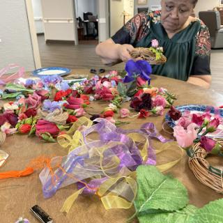 A creative workspace filled with colorful artificial flowers and ribbons, showcasing a crafting activity.