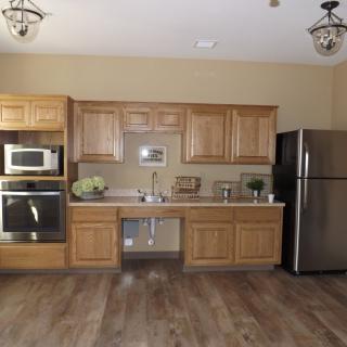 A modern kitchen with wooden cabinets, a stainless steel refrigerator, and built-in appliances.