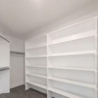 Empty storage room with white shelves and walls.