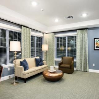A modern living room with stylish furniture, large windows, and soft lighting.