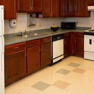 A modern kitchen featuring wooden cabinets, a countertop, and essential appliances.