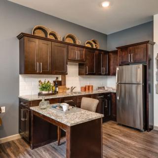Modern kitchen with dark cabinets and stainless steel appliances.