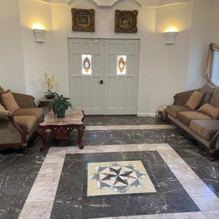 A classic living room with twin sofas facing each other, a central coffee table, and intricate tiled flooring.