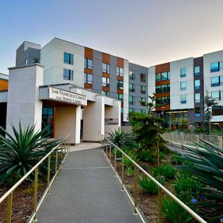 A modern hotel with contemporary architecture and landscaped pathways.