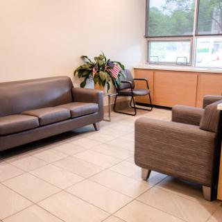A cozy waiting area featuring a sofa, armchairs, and a touch of greenery.