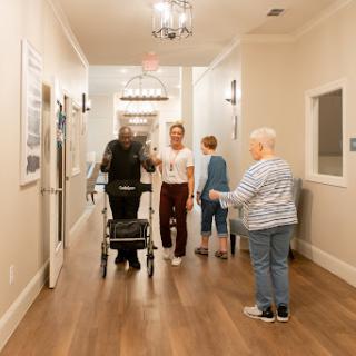 Residents and staff interact in a warm, supportive environment within a care facility.
