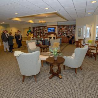 A comfortable lounge area with chairs and tables, where people are gathered.