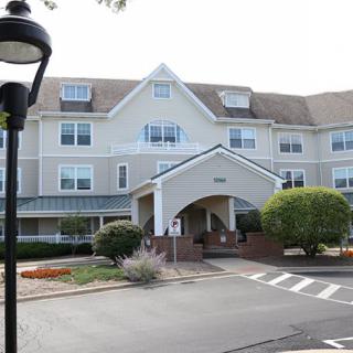 A suburban residential building with a covered entrance and landscaped surroundings.