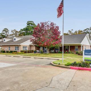 A single-story building with an American flag in front and well-maintained landscaping.