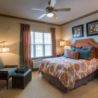 A cozy bedroom interior with a patterned bedspread and elegant decor.