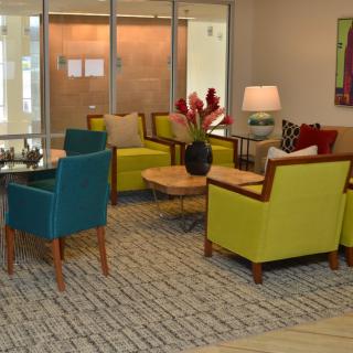 A modern living room with colorful chairs and a cozy seating area.