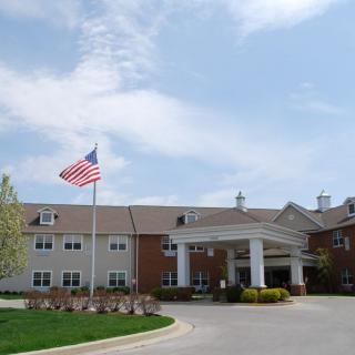 A building with an American flag at the entrance on a sunny day.