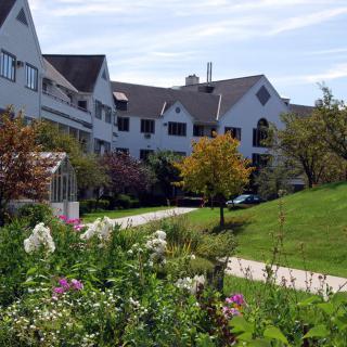 A picturesque view of a building surrounded by a lush garden and greenery.