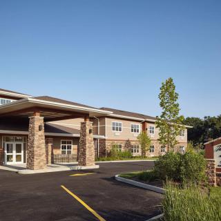 A modern building with a landscaped entrance and clear blue sky.