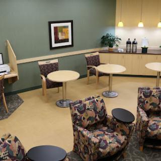 A cozy waiting area featuring comfortable seating and a coffee station.