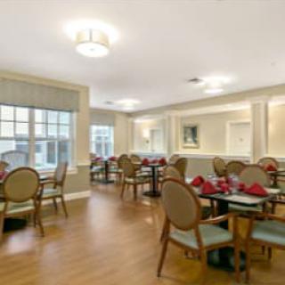 A well-lit dining room with neatly arranged tables and chairs.