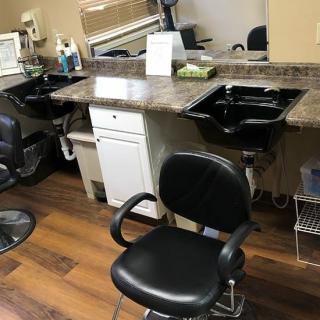 A hair salon setup featuring barber chairs, sinks, and workstations.