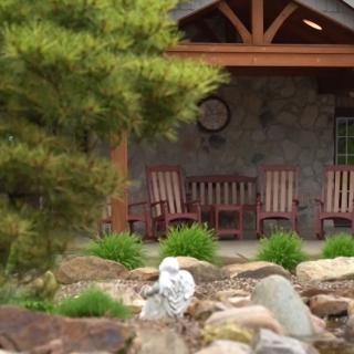 A cozy porch with rocking chairs overlooks a beautifully landscaped garden.