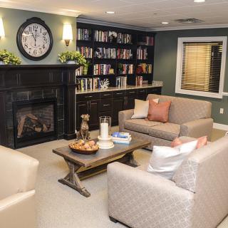Cozy living room with a fireplace, bookshelves, and comfortable seating.