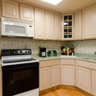 Modern kitchen with light-colored cabinets and appliances.