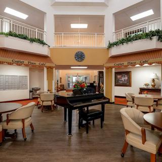 A spacious lobby area featuring a grand piano and comfortable seating arrangements.