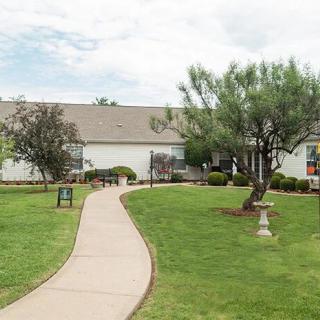 A house with a well-maintained garden and a winding pathway leading to the entrance.