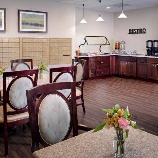 A cozy dining area with elegant seating and a kitchenette in the background.